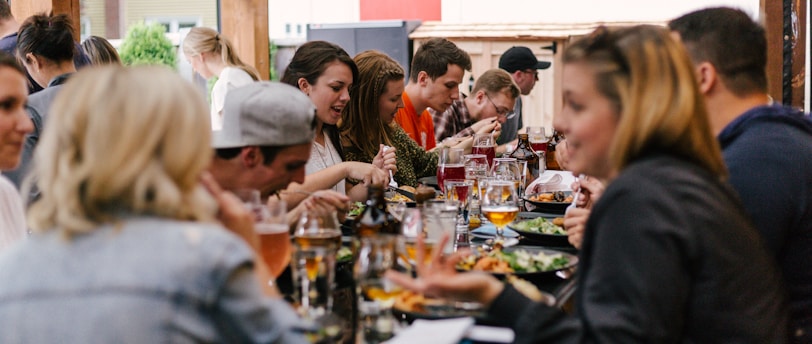 people sitting in front of table talking and eating