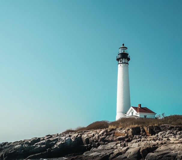 A lighthouse on a rocky shore under a blue sky in long island, new york A lighthouse on a rocky shore under a blue sky in long island, new york