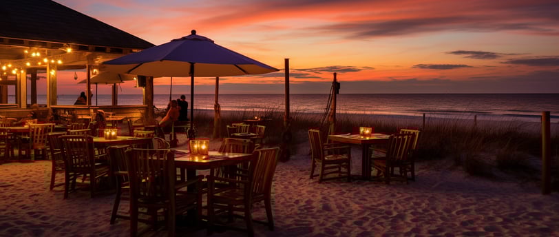 a restaurant with tables and umbrellas on the beach