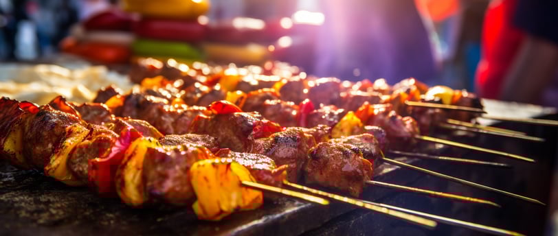 a bunch of skewers of meat on a grill