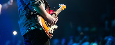selective focus photography of man playing electric guitar on stage selective focus photography of man playing electric guitar on stage