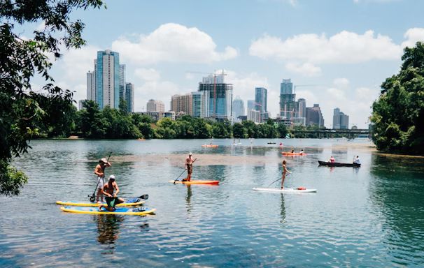 people riding paddle boards on the lake people riding paddle boards on the lake