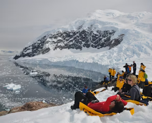 people on snow toward body of water people on snow toward body of water