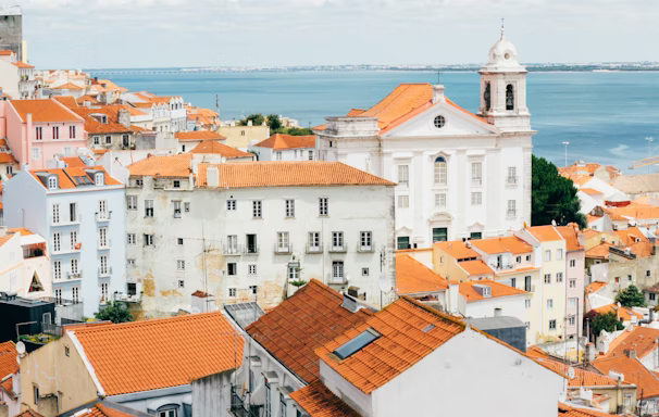 landscape photography of orange roof houses near body of water landscape photography of orange roof houses near body of water