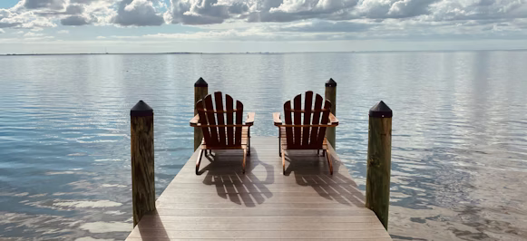 brown wooden dock on sea under blue sky during daytime brown wooden dock on sea under blue sky during daytime