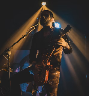 man in black jacket playing guitar man in black jacket playing guitar
