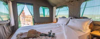 a bed in a tent with a hat on top of it a bed in a tent with a hat on top of it
