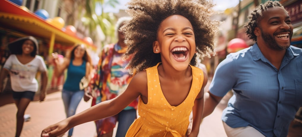a group of children and adults laughing and rushing through the gates of a theme park in Orlando, Fl