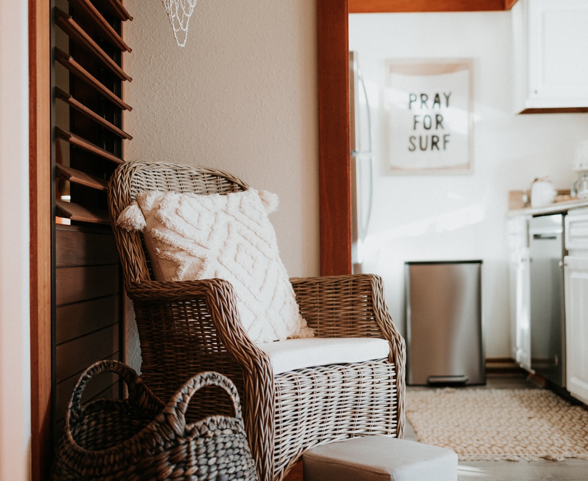 a wicker chair and foot stool in a kitchen