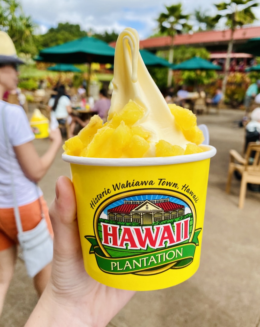 person holding a blue and yellow cup with yellow ice cream