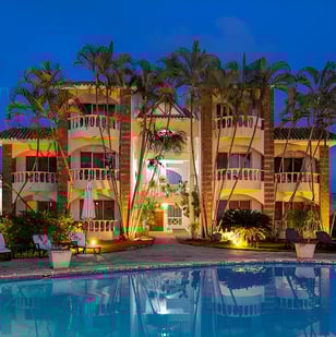 A pool with a view of a hotel and palm trees  in puerto plata, dominican republic A pool with a view of a hotel and palm trees  in puerto plata, dominican republic