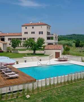 A spacious house with a pool and green lawn