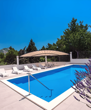 A serene pool area with sun loungers and umbrellas, perfect for relaxation under the sun