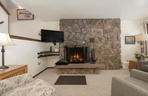Opulent ski suite interior with sophisticated furnishings and breathtaking mountain views under natural light. hideaway-village-alpin-us-winter-park-bc-9558150-1